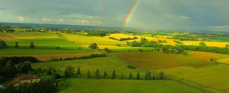 Une vue de la campagne gersoise avec un arc en ciel